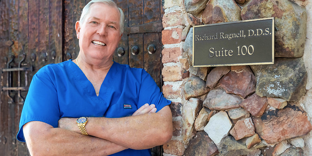Dr. Richard Ragnell posing next to his name plate in front of iSmile Dental, located in Plano,TX
